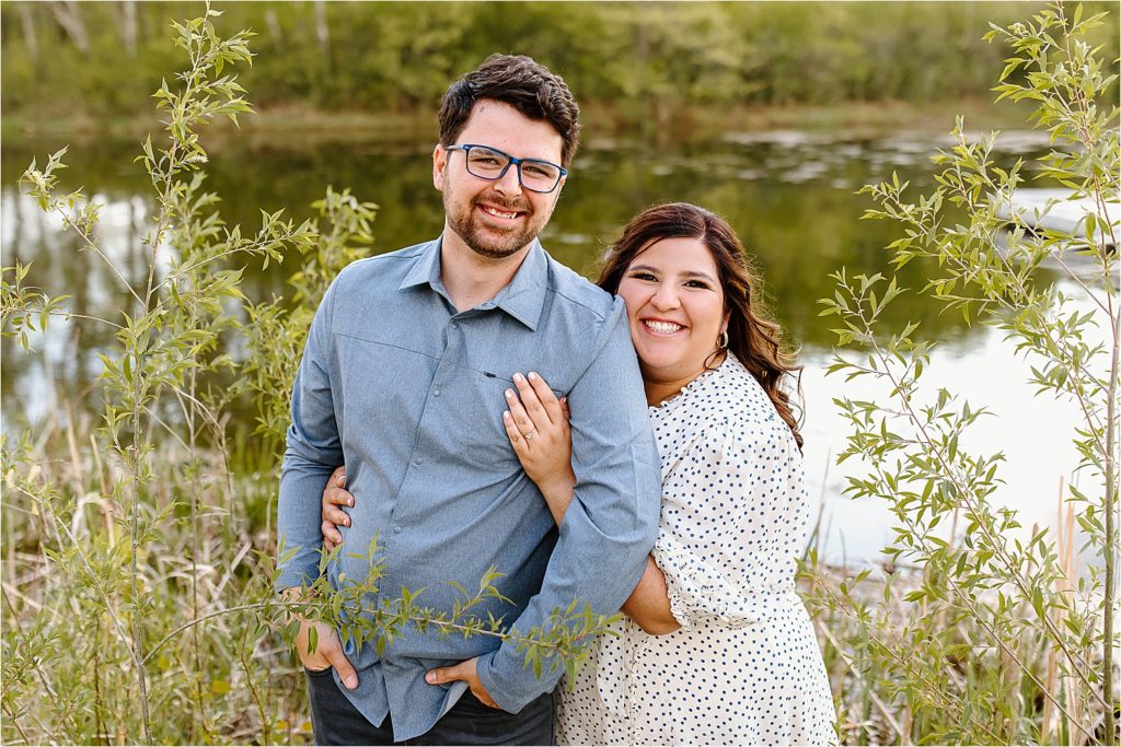 couple looking at camera smiling by lake