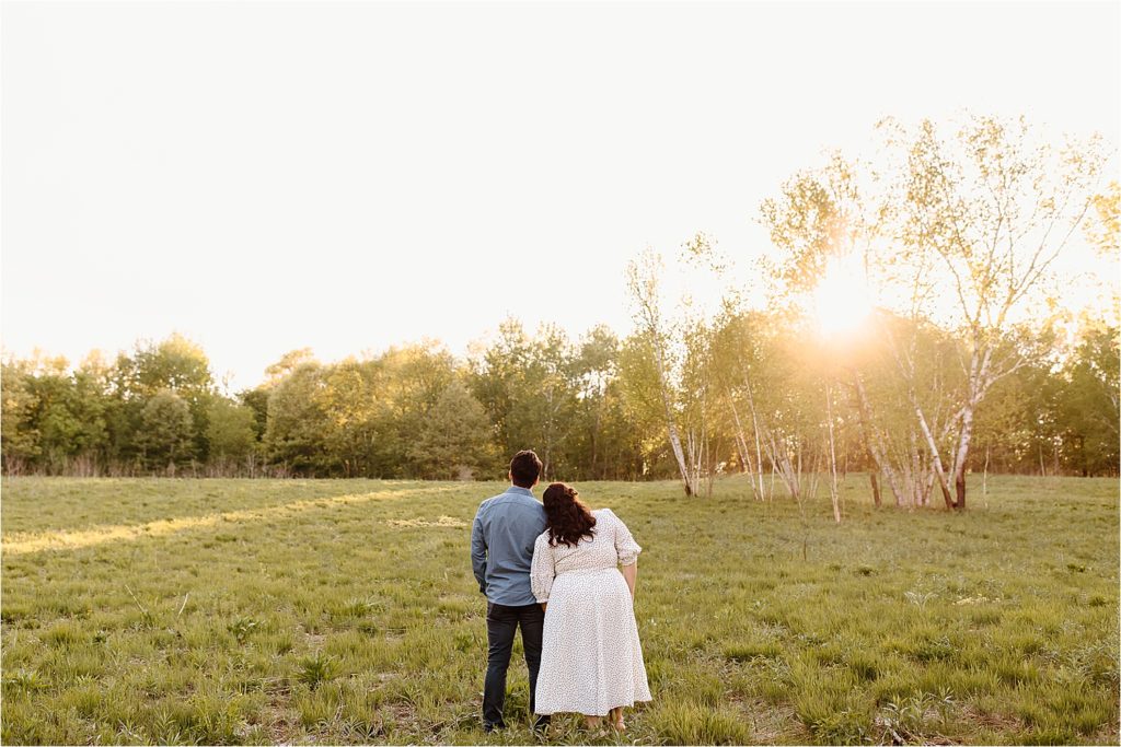 couple looking at the sunset in field