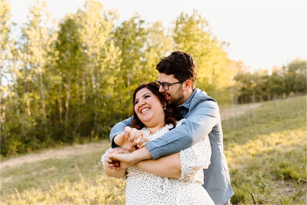 couple hugging and smiling in field