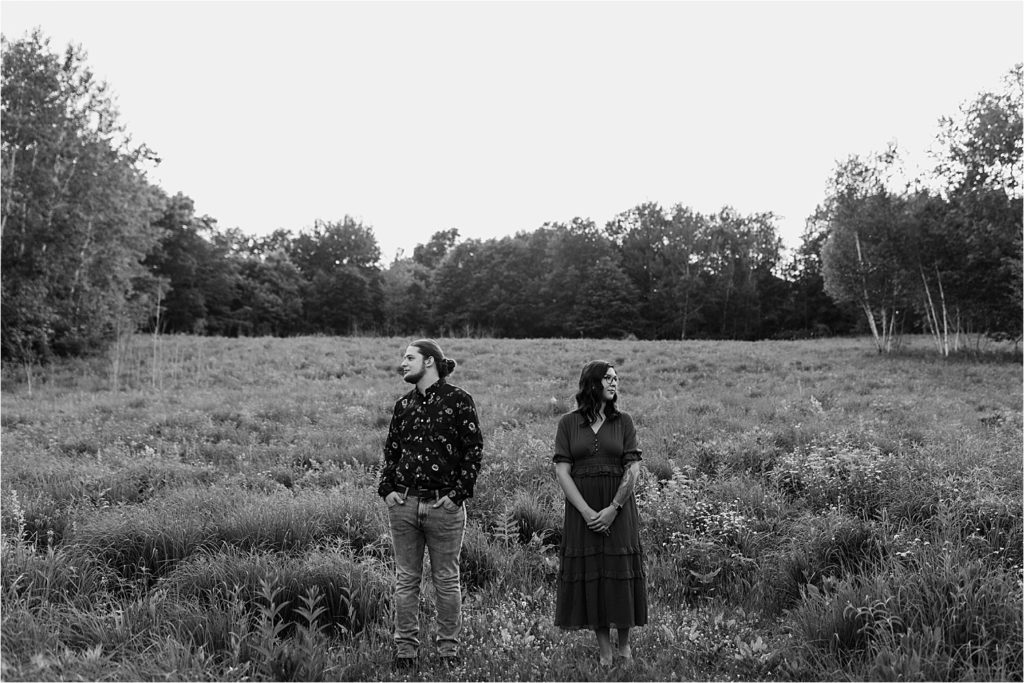 black and white photo of couple looking away from eachother in field