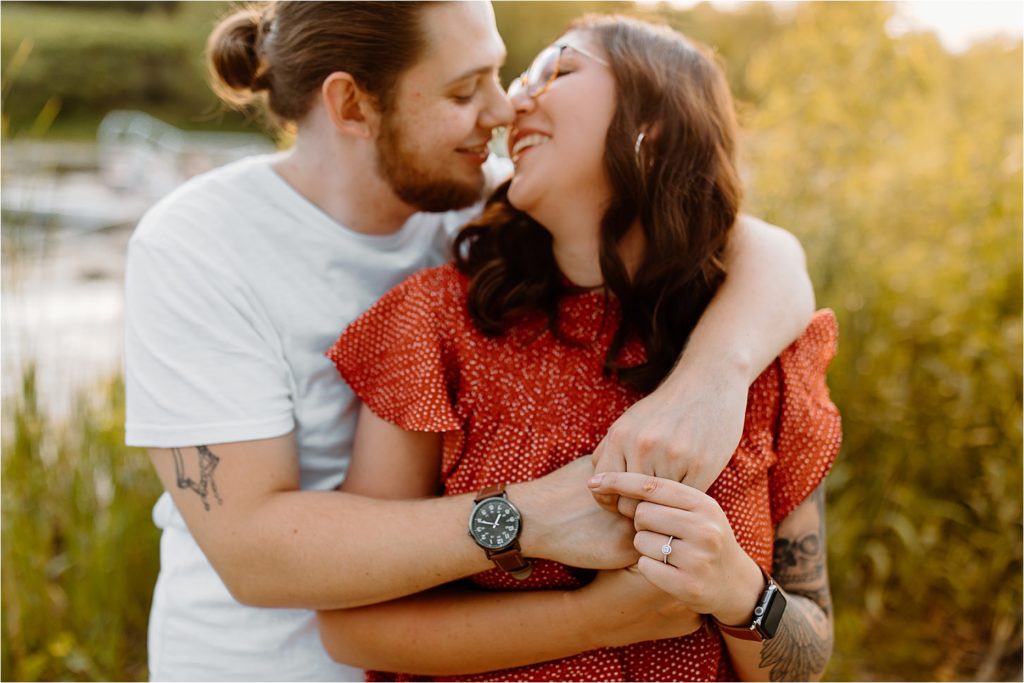 couple smiling showing engagement ring