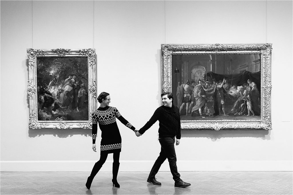 Couple walking holding hands while looking at each other in the Minneapolis Institute of Art