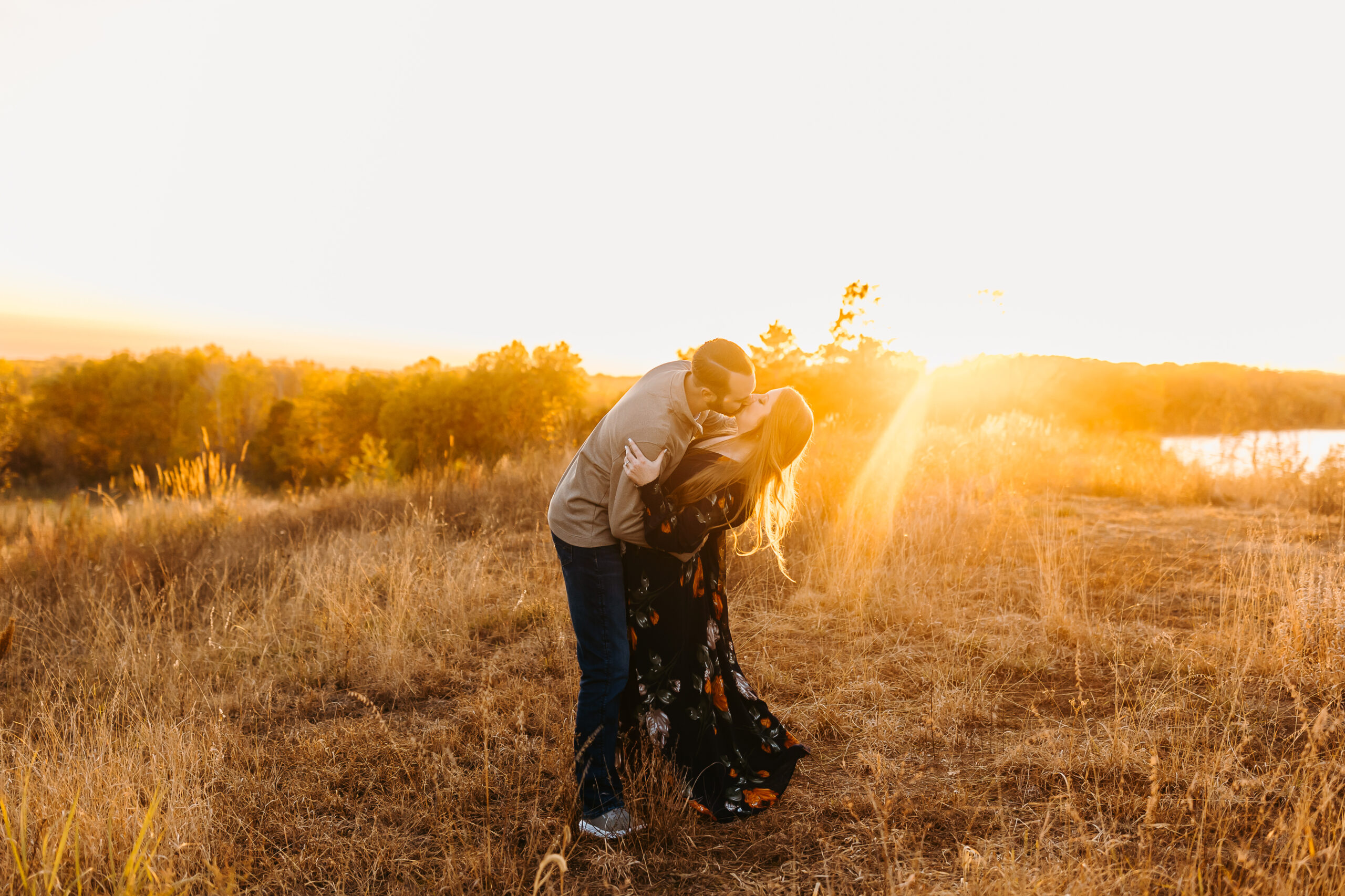 Couple kissing with the sun setting behind them