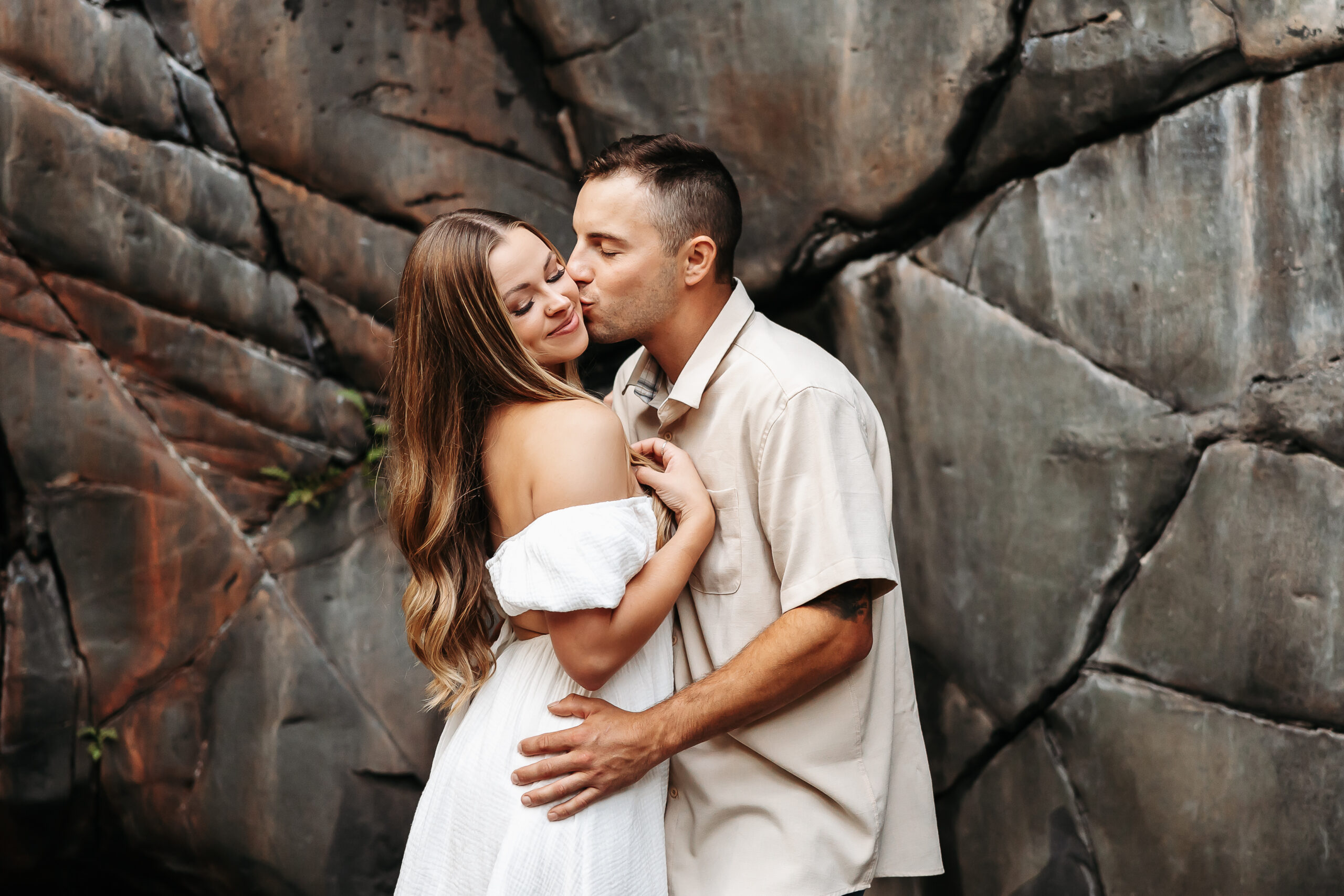 Man kissing woman on cheek with both eyes closed