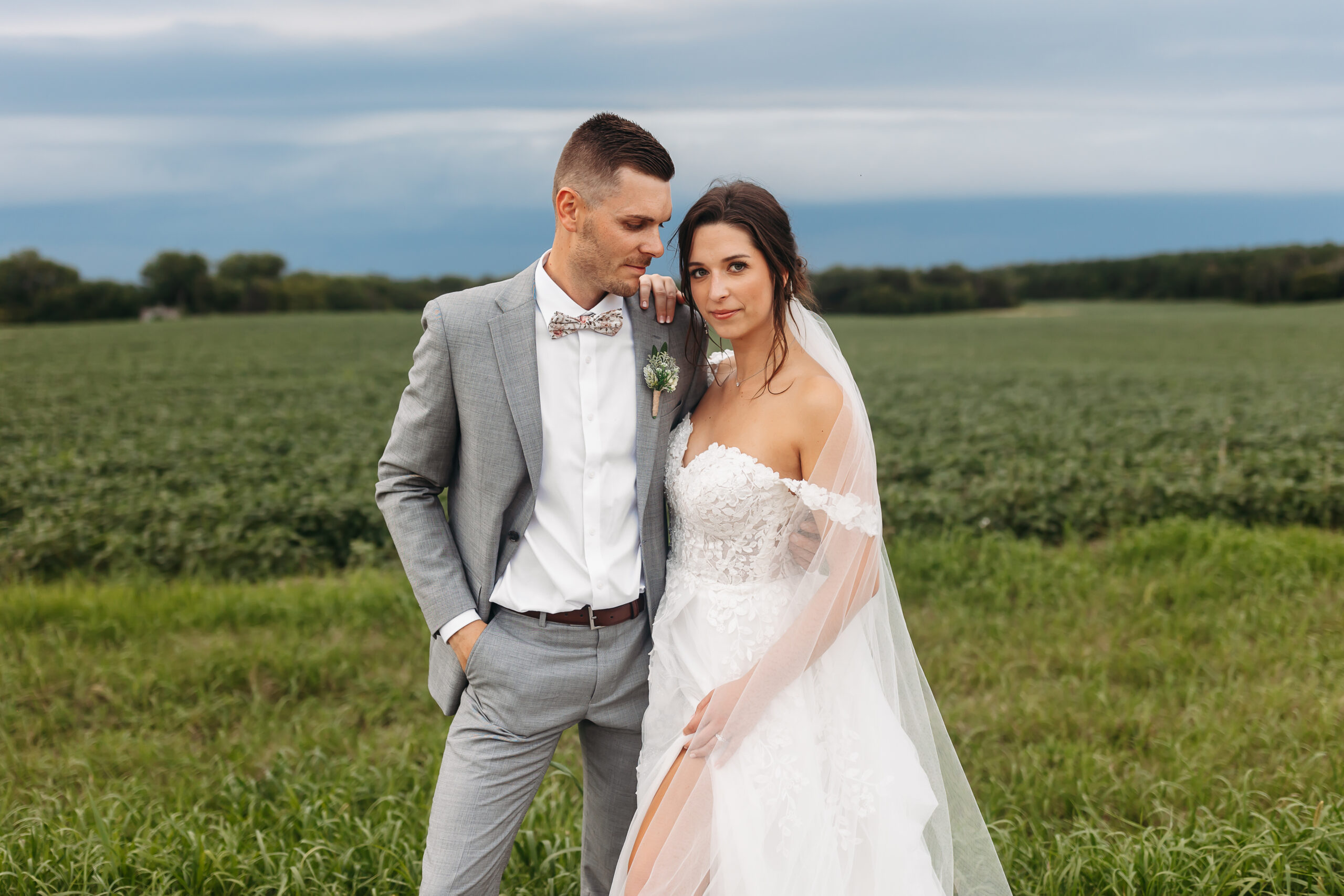 groom looking at bride with hand in pocket and bride looking at camera